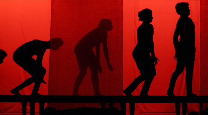 expressive human shadows on red lit stage